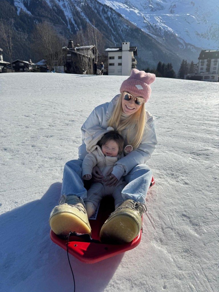Mama sledging with infant at snowy Chamonix resort for non-skiers
