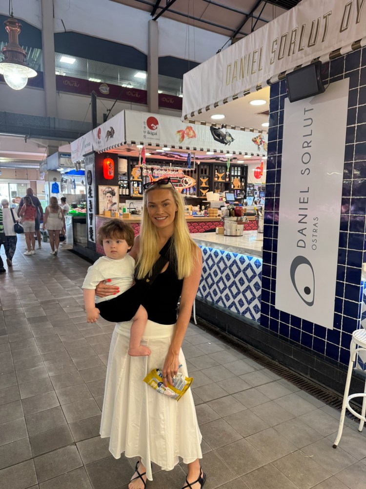 Baby in baby carrier at Mallorca market family holiday